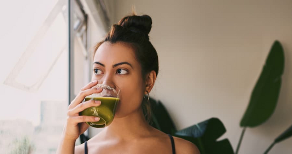 indian girl sipping green drink.png